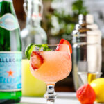 Photo of Strawberry Limoncello Fizz Cocktail with strawberry basil simple syrup, fresh strawberries, lemon juice with a basil garnish in a glass of ice.